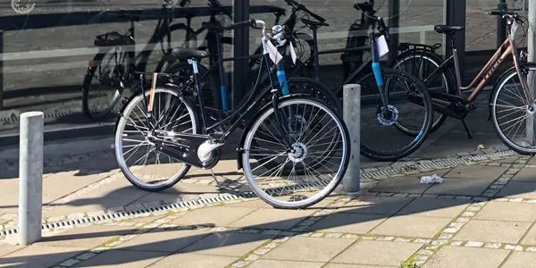 Cykler stillet ved døren til værkstedet på Oddervej 174 i Højbjerg, en af dem med en seddel på styret